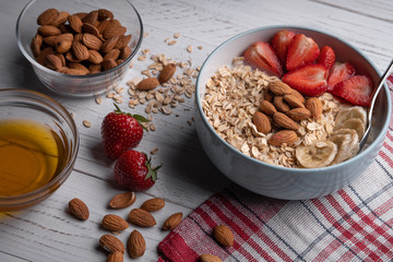 Oatmeal with berries, nuts, honey on white background. Healthy breakfast. Vegetarian food