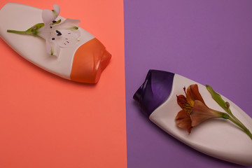 Beauty, decorative cosmetics bottles. Peach and purple colors background, flat lay, top view, minimalistic pop-art style