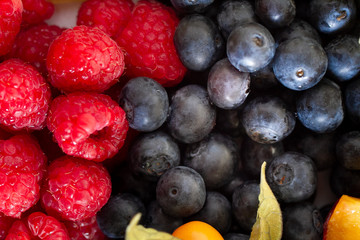 Beeren von roten Himbeeren Blaubeeren und physalis