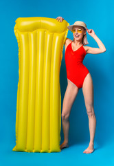Millennial Woman In Red Swimsuit With Yellow Swimming Mattress