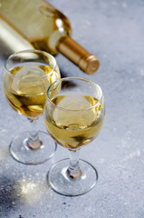 White wine in glass wine glasses, a bottle of wine. Blue background. Copy space