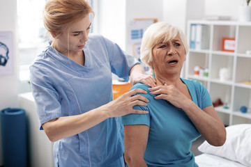 Nice aged woman screaming from pain in the shoulder