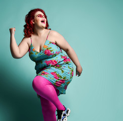 Laughing plus-size lady overweight woman in fashion sunglasses and sundress running from something...
