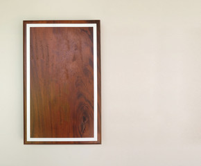 Empty brown wood frame on gray cement wall.