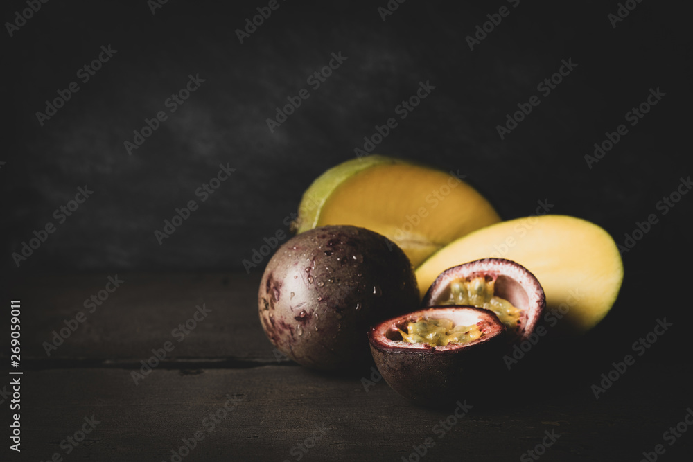 Wall mural mango and passion fruit on dark background