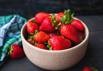 Close-up of fresh strawberries in a bowl on wooden background