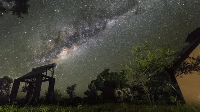 Beautiful Milky way rises behind the silhouette of a solar water heater and thatched huts at Isalo National Park, near the town of Ranohira, Madagascar