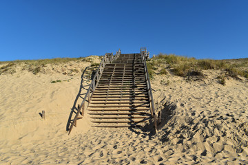 Un escalier en bois pour aider à franchir la dune de sable au bord de l'Océan Atlantique