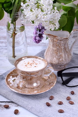 Freshly brewed coffee with a milky foam topped with cinnamon in a brown cup