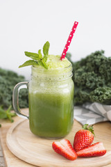 Green kale smoothie served with mint and strawberry. Healthy drink. Detox concept