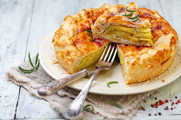 Puff pastry pie dish with potatoes and rosemary.