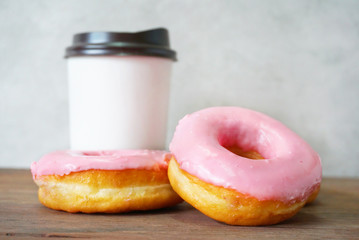 Two donuts with coffee cup on the table.