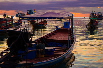 Fototapeta premium Silhouette seascape sunset wooden boat on sea shore