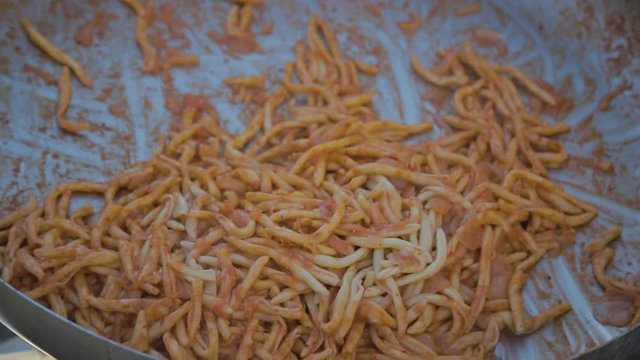 Pasta fresca fatta in casa che cucina in una grande padella da chef in alluminio