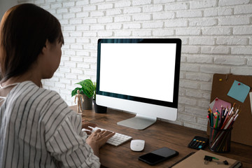 woman working empty screen computer on wood desk in home office.