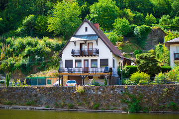 Vianden, Luxembourg; 08/12/2018: Typical house of Vianden in Luxembourg, with Our river in the foreground and a forest in the background