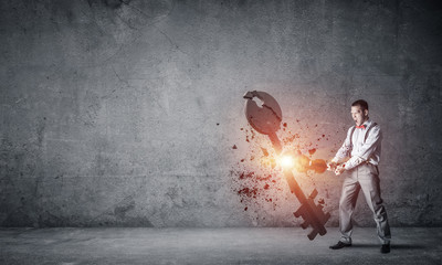 Breaking through access concept with man in room crashing concrete key