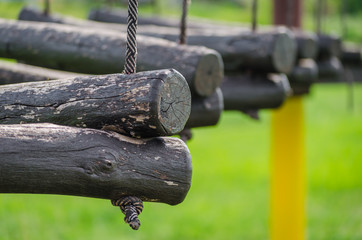 old wooden logs on a rope on a green background close up