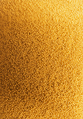 Many gold beads as background, view through glass