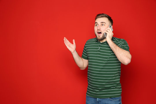 Portrait Of Emotional Man Talking On Phone Against Color Background. Space For Text