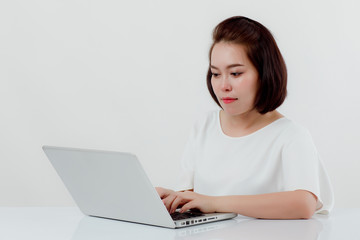 Naklejka premium Asian beautiful woman Sitting in a white shirt On the front desk, there is a laptop computer placed. Expression There is work stress. With a white background