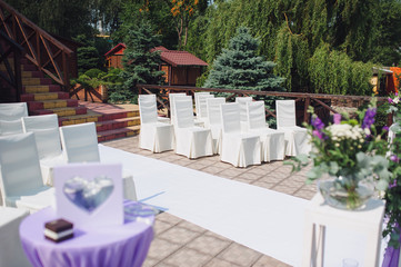 A white wedding track is spread out on the floor, and chairs for guests stand nearby. Wedding ceremony, the expectation of the newlyweds.