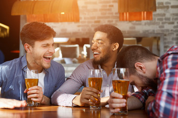 Diverse Friends Drinking Beer And Talking In Bar