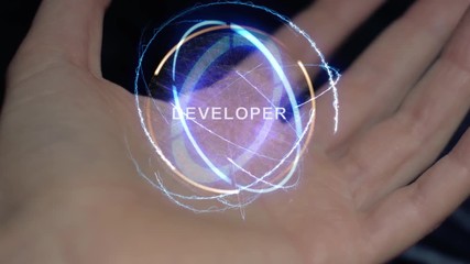 Developer text in a round conceptual hologram on a female hand. Close-up of a hand on a black background with future holographic technology