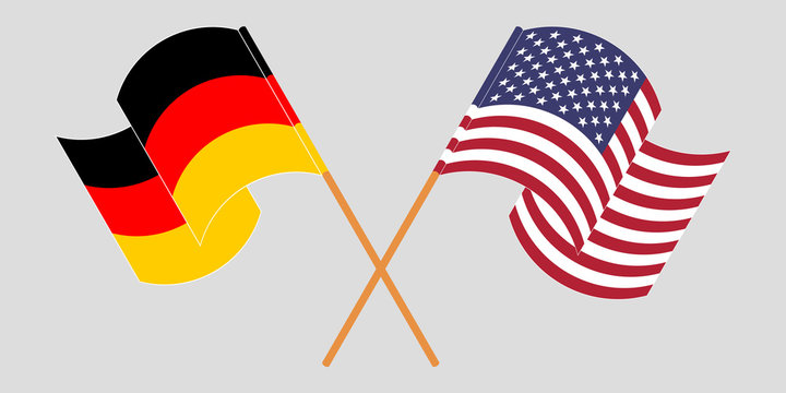 Crossed and waving flags of Germany and the USA