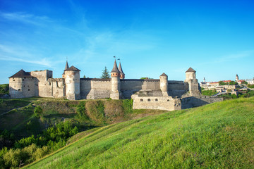 Fototapeta na wymiar Summer landscape with green fields, antique fortress Kamianets-Podilskyi in Ukraine
