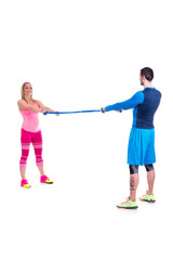 Naklejka premium Happy young couple doing exercise in pair with elastic rubber for pregnancy on the white background.