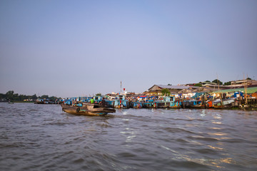Fototapeta na wymiar CAN Tho, Vietnam - March 27, 2019: the floating market of the Mekong in delta trading boats at dawn is a cruise on the Mekong River. Houses on stilts on the river