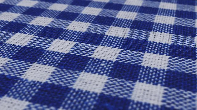 Blue white tablecloth, picnic gingham is pan camera movement. Close up macro shot checkered fabric cloth background.