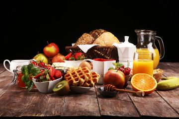 Breakfast served with coffee, orange juice, croissants and strawberry, jam and tea. breakfast table