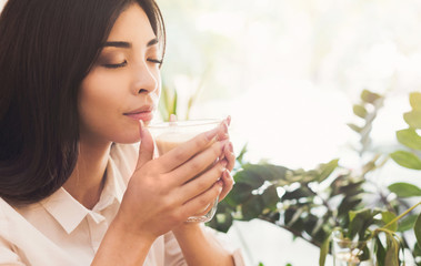 Attractive asian woman enjoying the smell of morning coffee