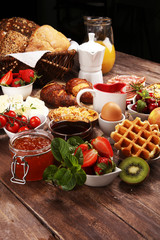 Breakfast served with coffee, orange juice, croissants and strawberry, jam and tea. breakfast table