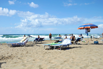 Relaxed people on the Sabaudia beach for the summer holidays. The Circeo Mountain on the...