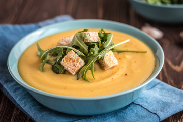 Pea soup with with croutons and greens on a wooden background. Pea cream soup.