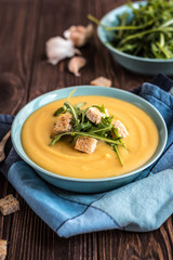 Pea soup with with croutons and greens on a wooden background. Pea cream soup.