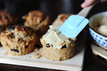 Freshly baked muffins on a wooden board. Glazing process