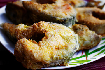 Fried fish in breading on a plate.
