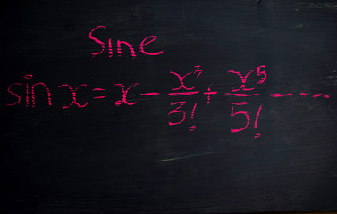 Close up math formulas written on a blackboard. Education concept