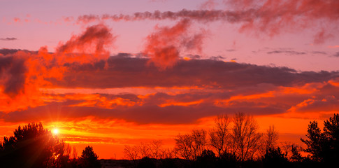 Fiery orange sunset  colorful and speckled  clouds.