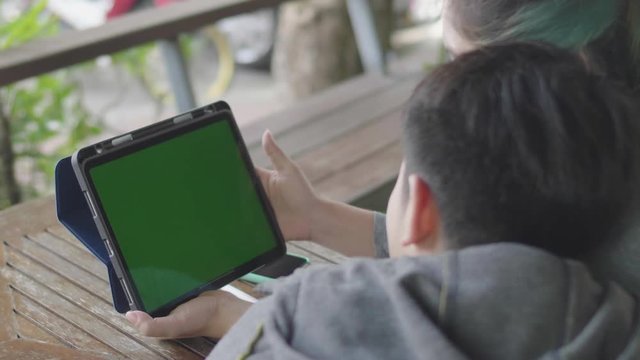 Mother and Son using digital tablet together, Green screen chroma key.