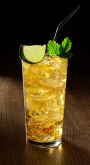 Ice lemonade with mint and lime  in a  glass on wooden background