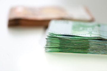 Euro banknotes arranged in a pile. A large amount of money with a shallow depth of field.