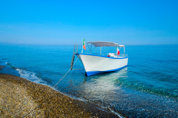 White Boat in a blue sea with cloudless sky