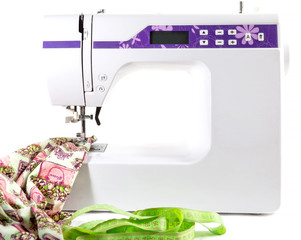 Electric sewing machine with sewing accessories isolated on white background