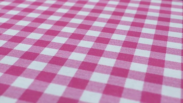 Pink white tablecloth, picnic gingham is pan camera movement. Close up macro shot checkered fabric cloth background.