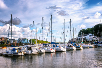 Fototapeta na wymiar Sailing Boats in Harbour cloudy skies